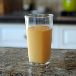 A glass with pumpkin shake on a kitchen counter.