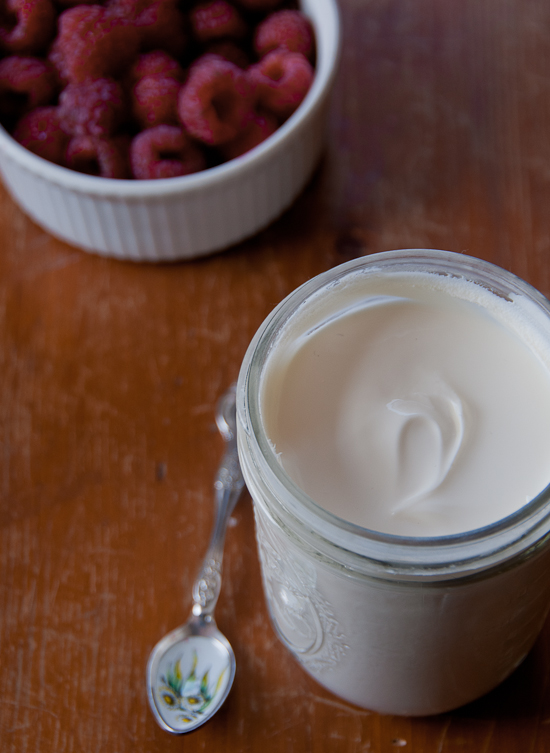DIY crème fraîche in a glass jar with raspberries in a ramakin. 
