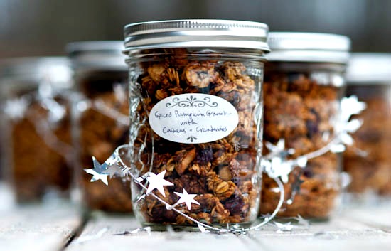 Jars of spiced pumpkin granola with festive decorations.
