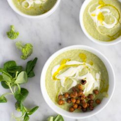 cropped image of 3 bowls of broccoli and quinoa soup topped with spicy roasted chickpeas