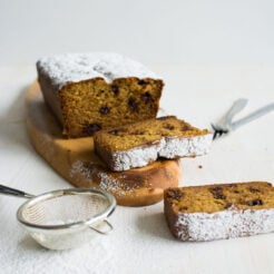 cropped image of a single loaf of Chocolate Stuffed Banana Bread, sliced into two portions. The moist and decadent bread is topped with chocolate chips