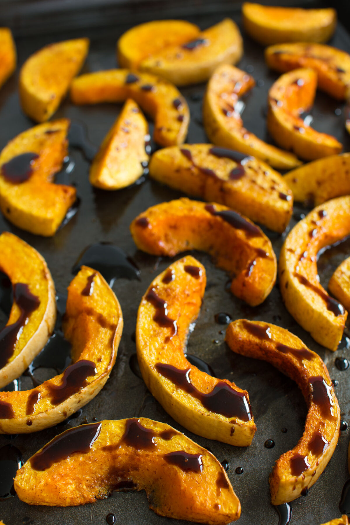 close up image of sliced roasted butternut squash drizzled with balsamic glaze 