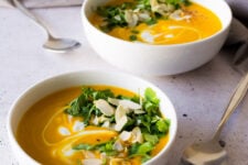 Spicy sweet potato soup served in two white bowls.