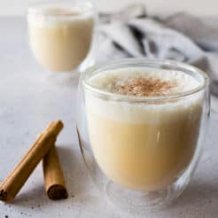 an image of two glasses full of homemade eggnog top with nutmeg