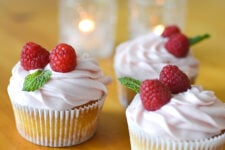 an image of 3 lemon raspberry cupcakes topped with fresh raspberry