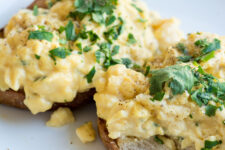 bread with scrambled egg topped with fresh parsley