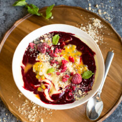Vegan Mango smoothie bowl with an easy raspberry sauce. Perfect for a colourful morning! Click through for the recipe!