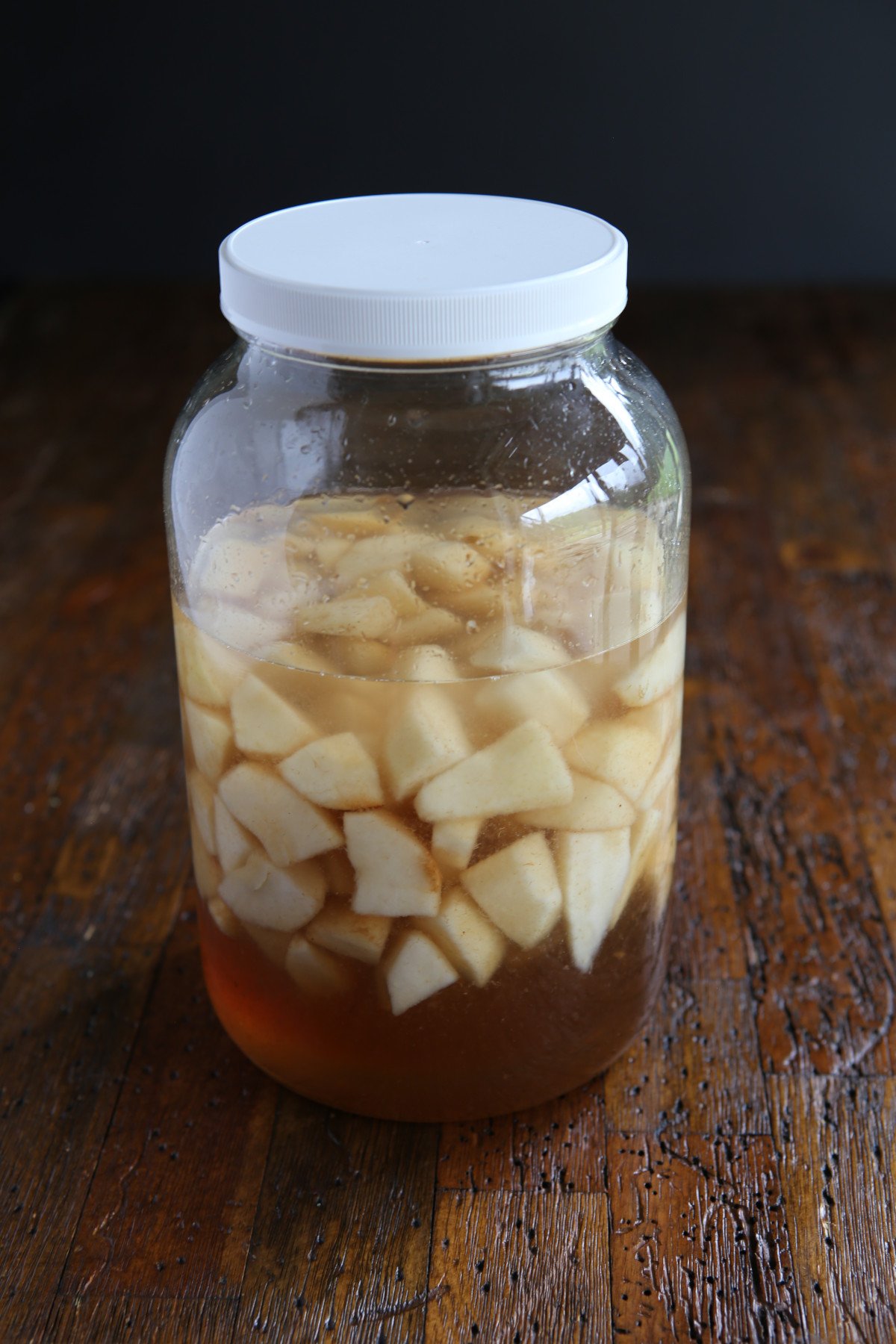 Pear liqueur resting in a 1-gallon jar.