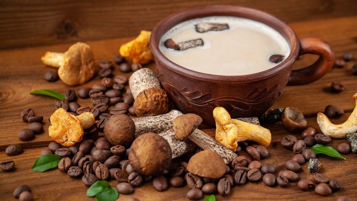 An assortment of functional mushrooms arranged near a cup of mushroom coffee.