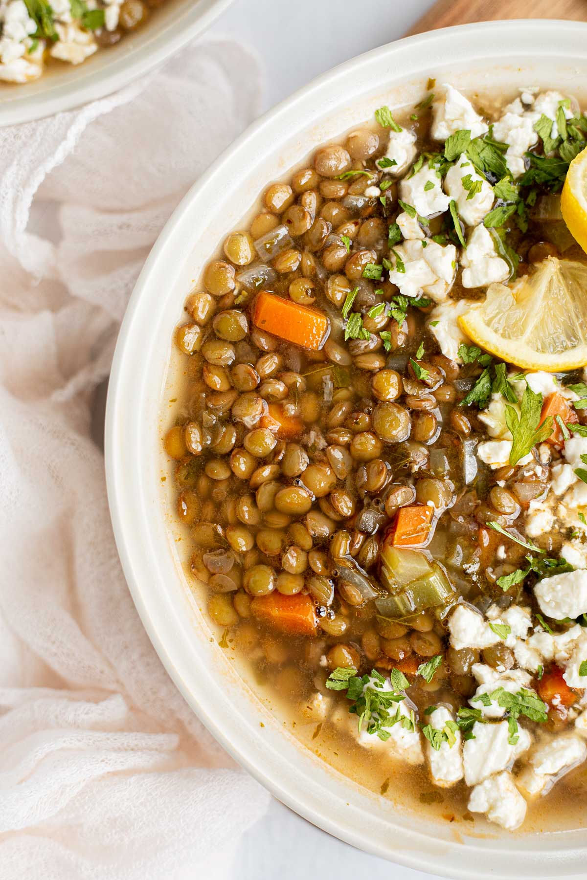 Close-up view of Greek Lentil Soup in a white bowl.