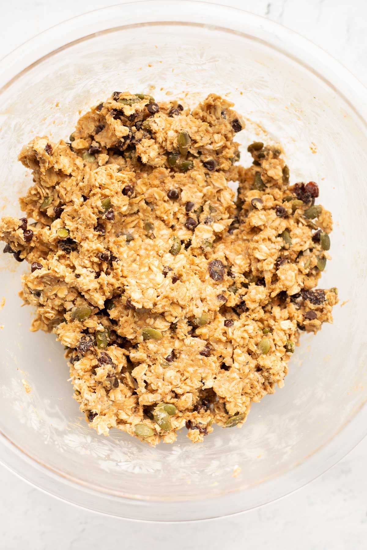 Ingredients for homemade protein bars mixed together in a glass bowl.