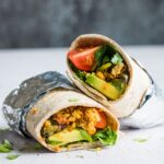 Two vegan breakfast burritos showing the inside of the burrito.