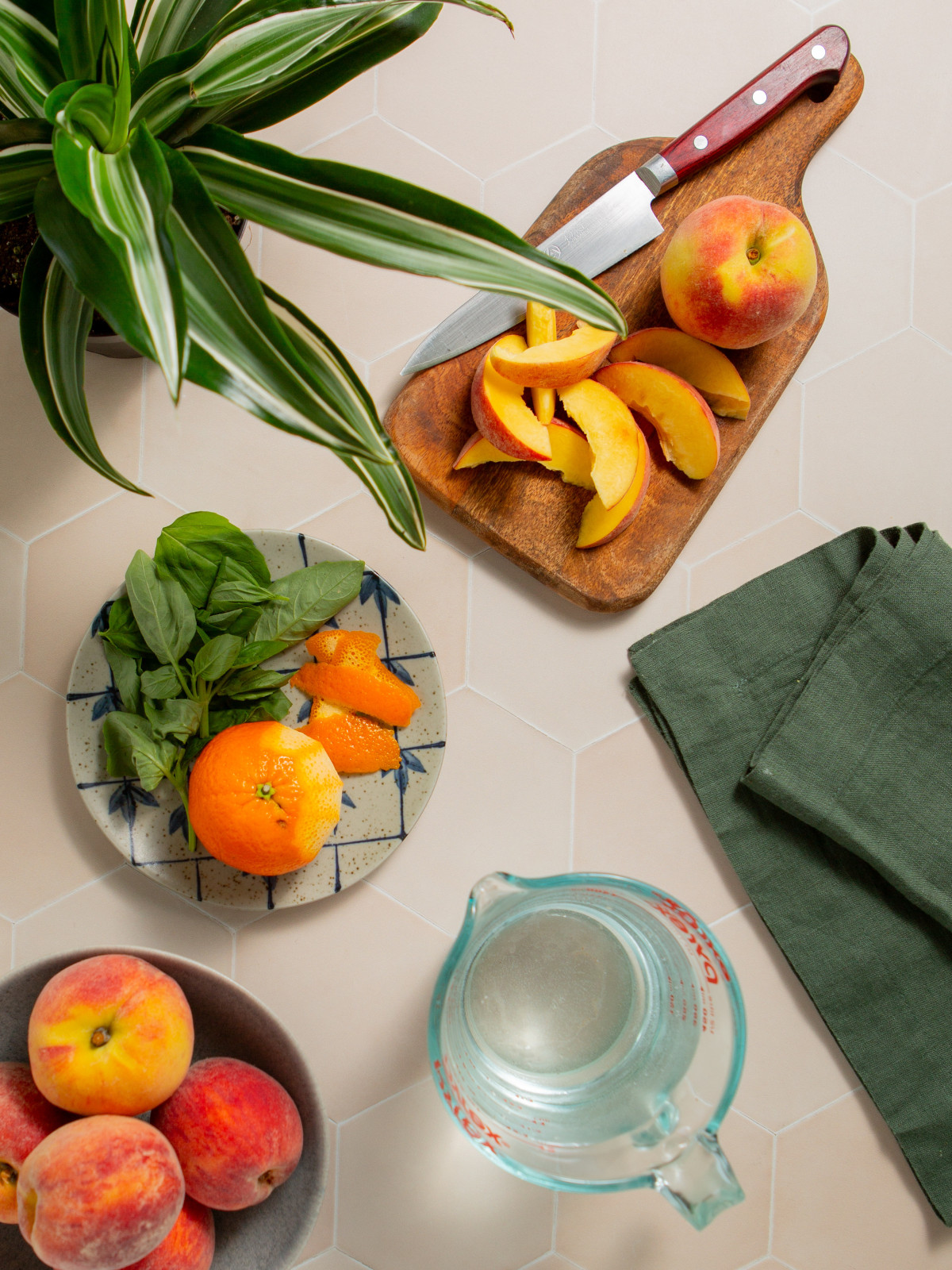 Ingredients laid out on a countertop for making peach infused water with basil.