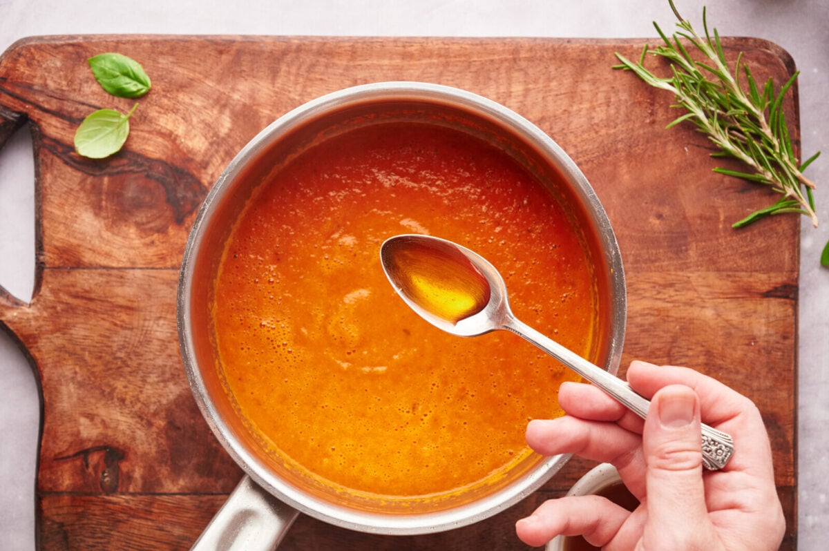 Drizzling a bit of maple syrup into a pot of tomato soup.