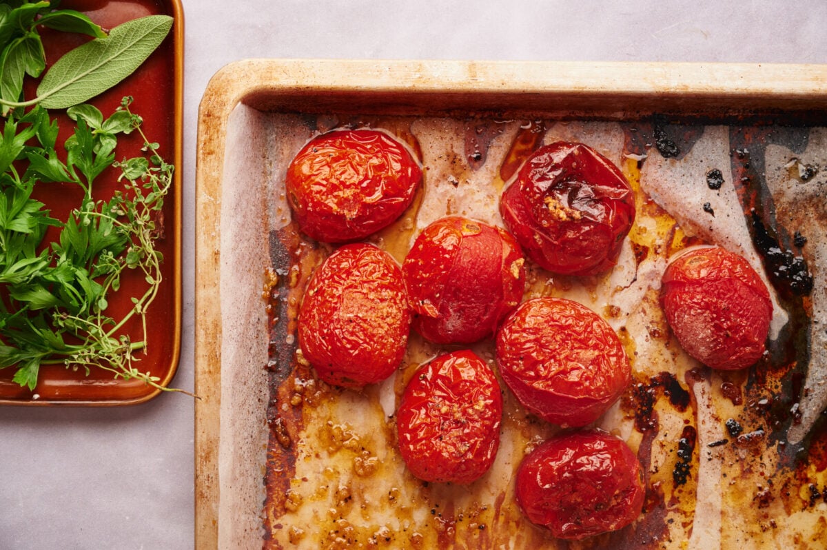 Perfectly caramelized oven roasted plum tomatoes on a parchment lined baking sheet.