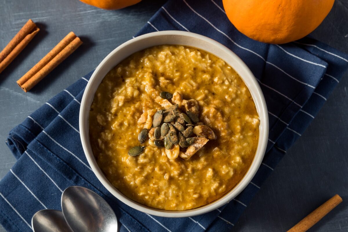 A bowl of pumpkin oatmeal garnished with seeds.