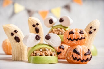Healthy Halloween snacks made from bananas, oranges, and apples.