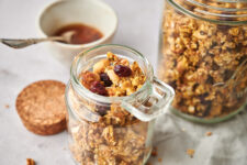 Close-up view of Pumpkin Spice Granola in a small jar with a larger jar behind it.