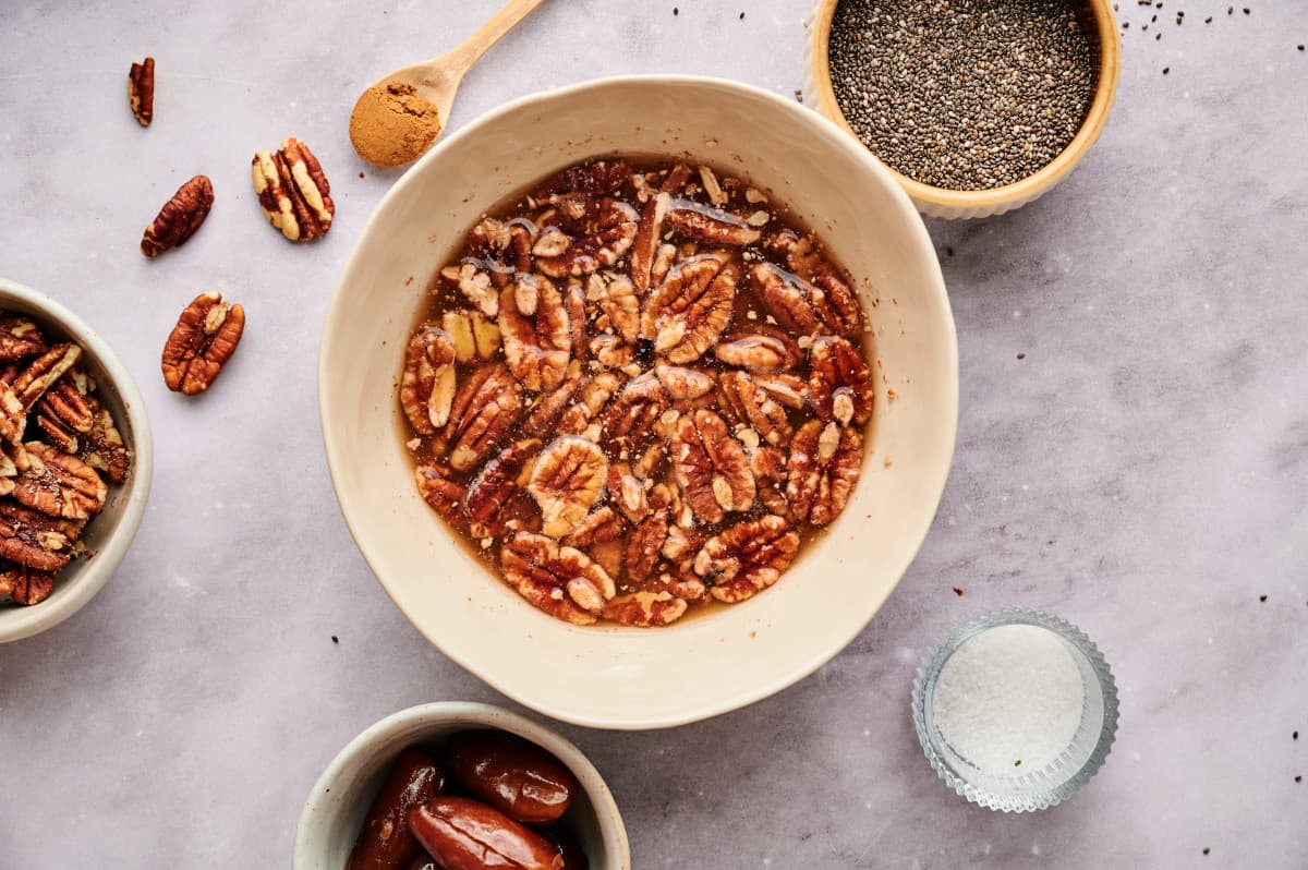 Pecans and dates being soaked in a bowl.
