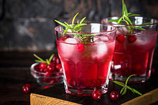 Holiday cocktail with cranberry, vodka, rosemary and ice.