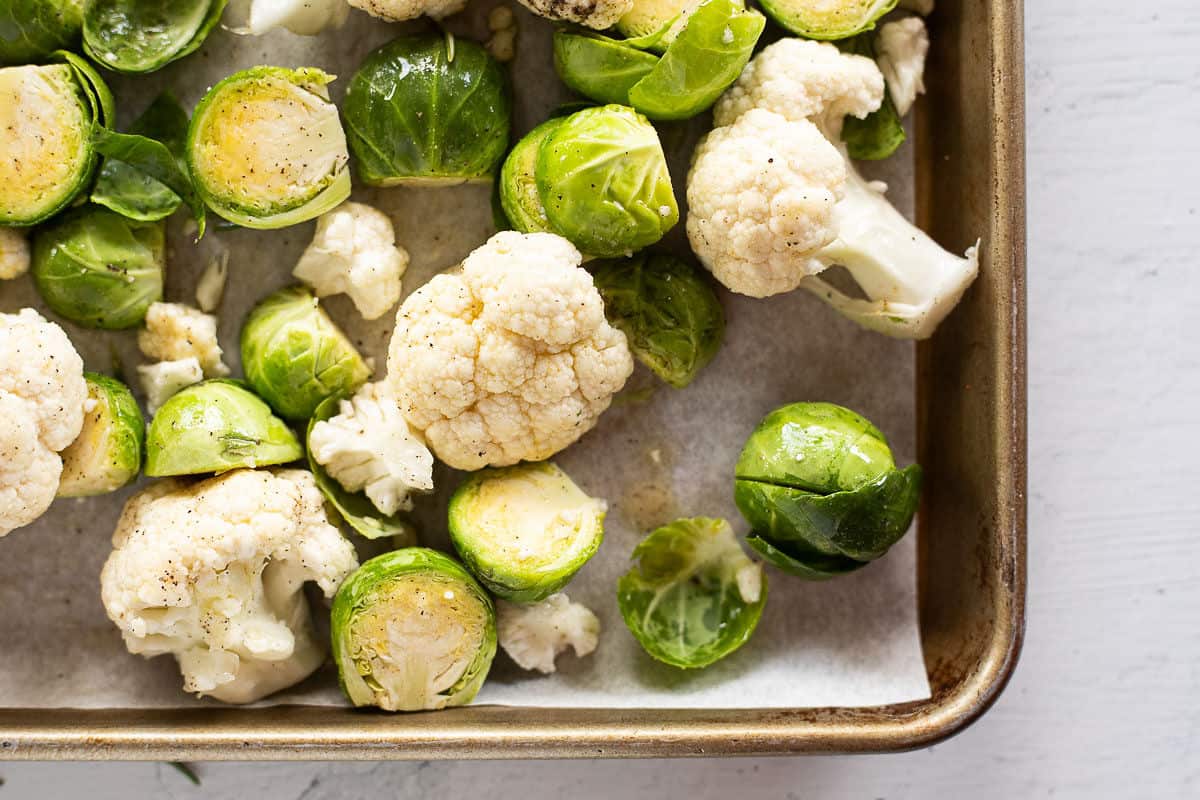 Cauliflower & Brussels Sprouts on a parchment lined baking sheet.