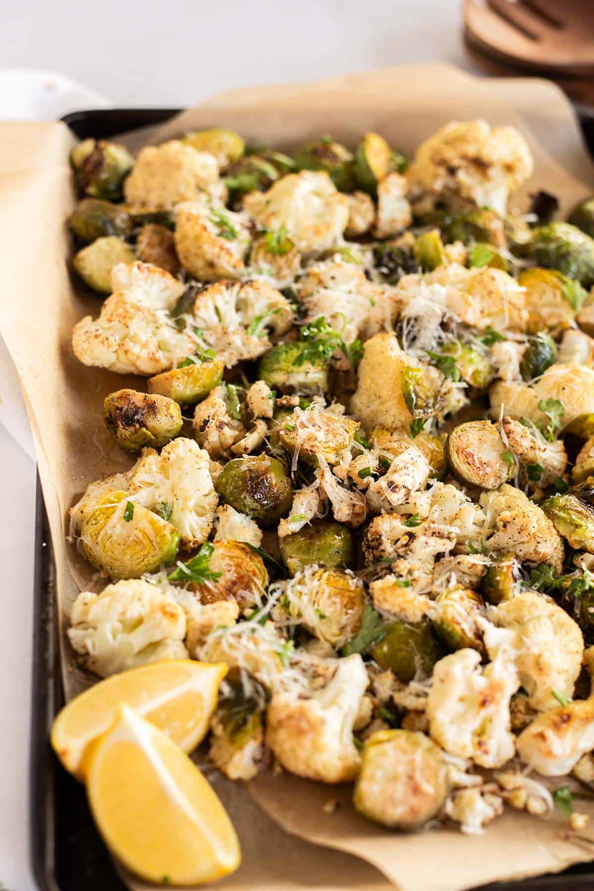 Roasted Cauliflower & Brussels Sprouts with Parmesan cheese on a parchment lined baking sheet.